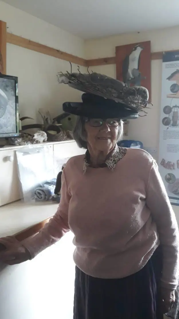 Woman wearing a hat shaped like an osprey