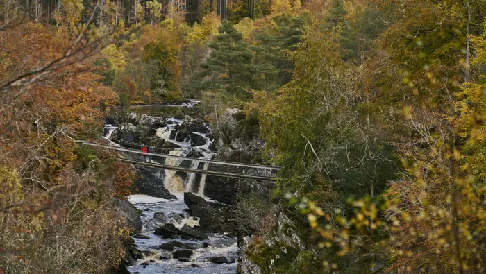 Bridge over a river with waterfall below.