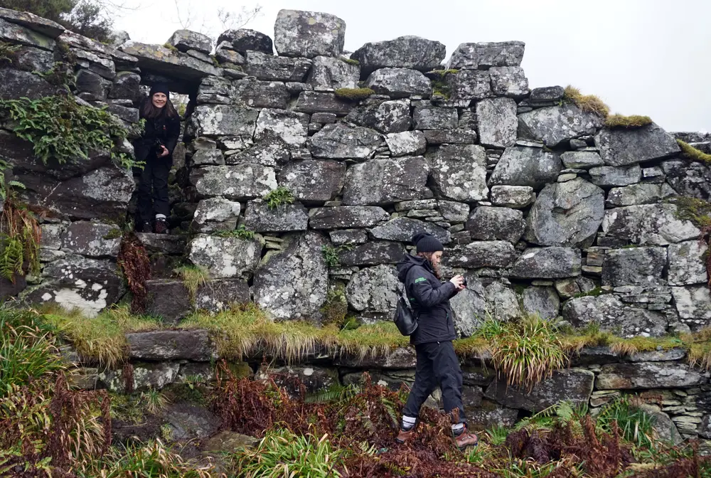 A female staff member exploring a stone broch