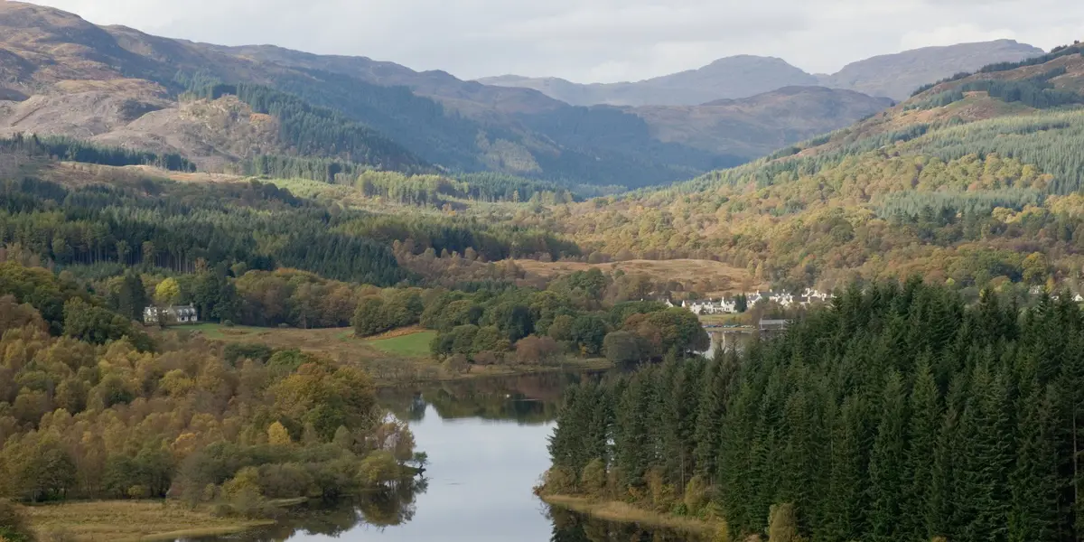 A view of Loch Ard with trees and hills on either side.