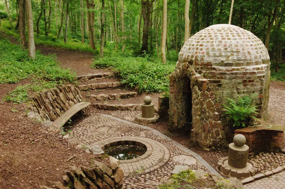 A stone shell building in a court yard in a forest