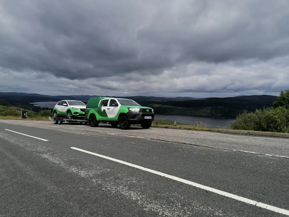 Two branded vehicles on side of road