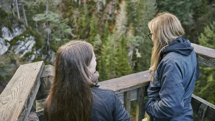 Two people looking down from a viewing platform.