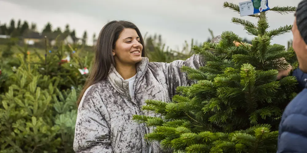 A woman and a man looking at a christmas tree