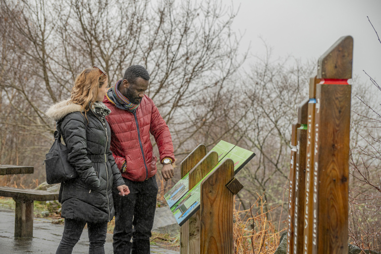 Couple looking at interpretation panels/signage at the trailheads at The Lodge Forest Visitor Centre