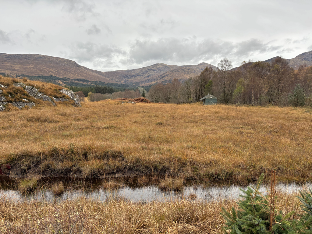A field surrounded by mountains and stone buildings