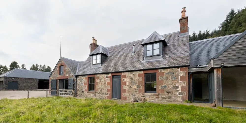 a stone building with a garage behind it