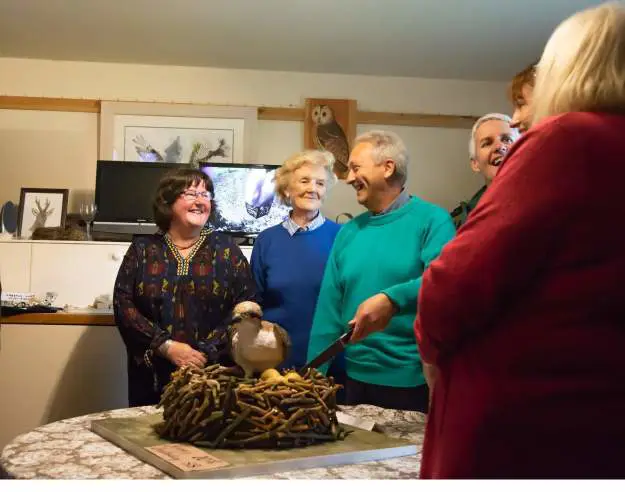 Group of people cutting a cake