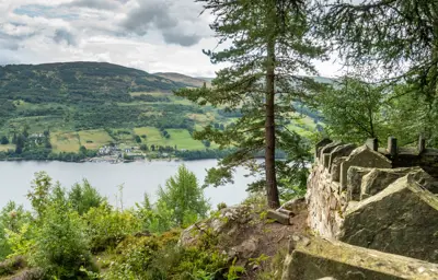 A stoned wall protecting a viewpoint looking over the river Tay with a village on the other side of the river