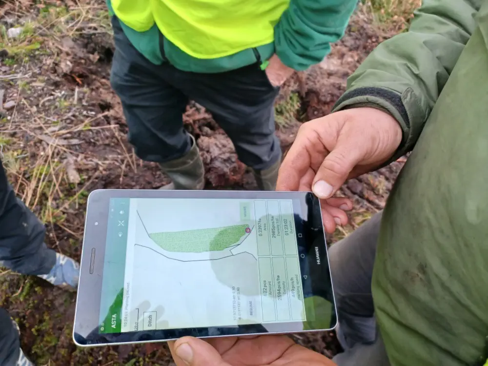 Staff members looking at a ipad that has gps mapped mounds 